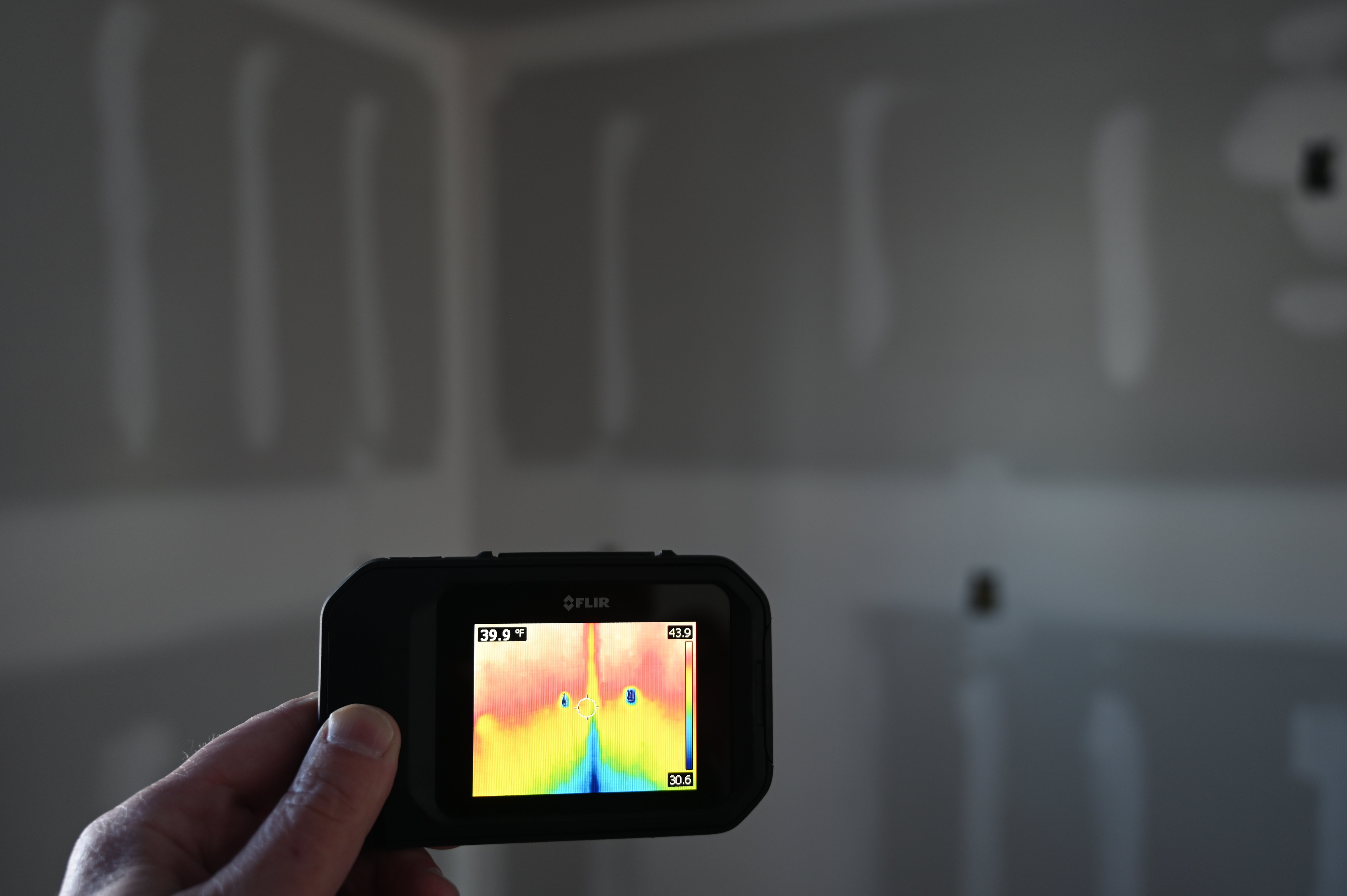 Thermal Camera showing cold air leaking in from corners during a Blower Door test 